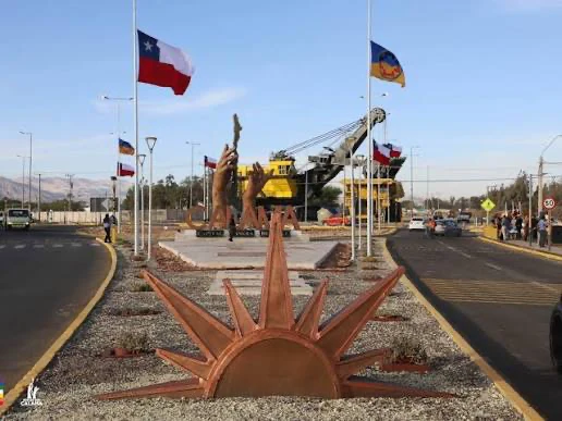 Rotonda de acceso a Calama, con banderas, esculturas y una pala minera