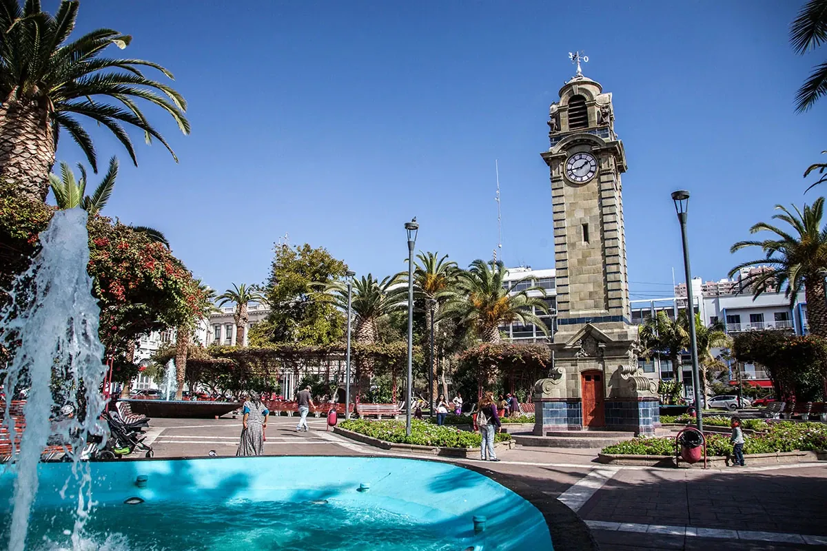 Plaza Colón de Antofagasta con la Torre Reloj, palmeras y pileta